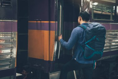 Ayakta ve platform üzerinde tren bekleyen genç Asyalı hipster adam.