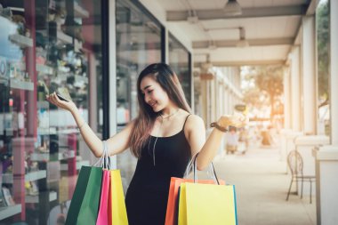 Asyalı kadınlar outl bir kağıt alışveriş çantası tutarken mutluyuz