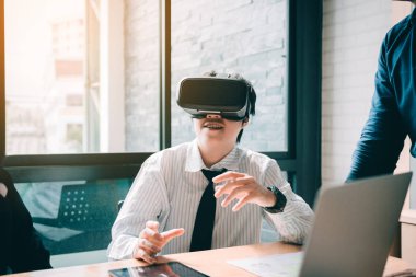 Genç iş adamları sanal gerçeklik vr kulaklık tekniklerini test ediyorlar.