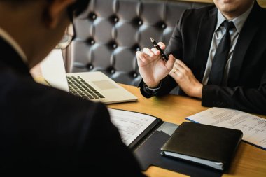 Erkek yönetici kalem tutar ve yeni emplo hakkında açıklıyor