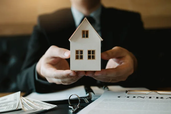 Pessoal de vendas imobiliárias dar a casa artificial para os clientes . — Fotografia de Stock