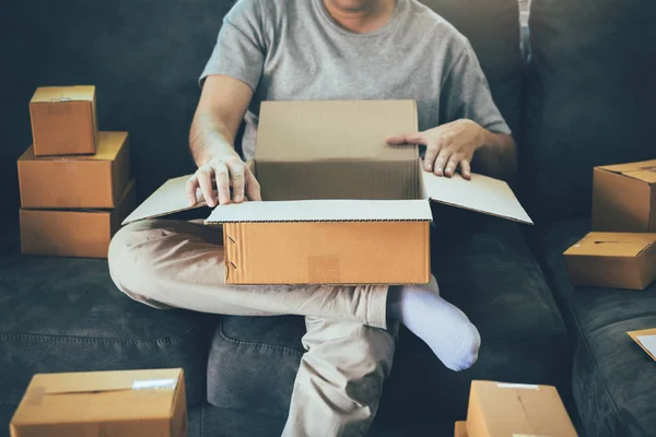 Asiático empreendedor adolescente está abrindo uma caixa de papelão em ordem — Fotografia de Stock