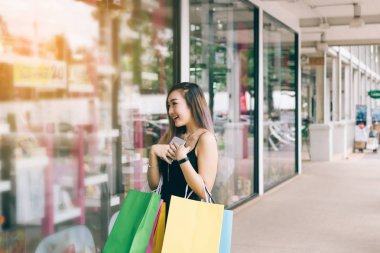 Asyalı kadınlar outl bir kağıt alışveriş çantası tutarken mutluyuz