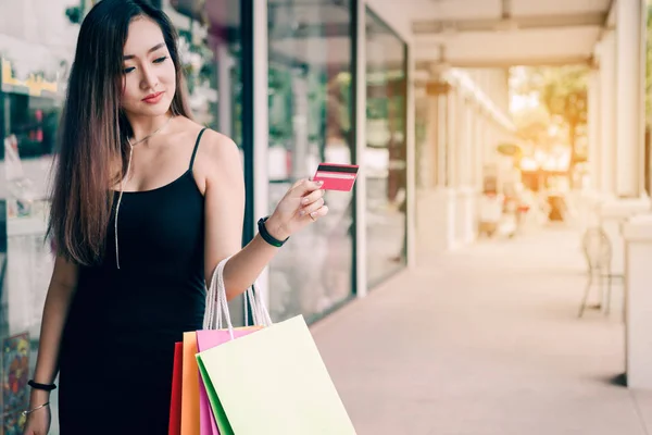 Stäng upp hand kvinnor innehar kreditkort och shoppingkassar på — Stockfoto
