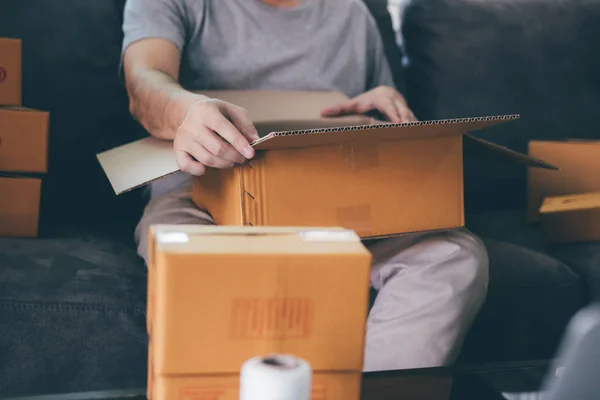 Asiático empresario adolescente está abriendo una caja de cartón con el fin de — Foto de Stock