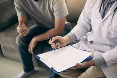 Doktor hastanın bilgilerini kaydederken, hasta 