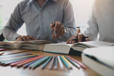 Kütüphanede sınava hazırlanan kitaplarla Asyalı öğrenci eğitimi.