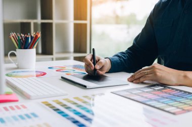 Serbest yaratıcı tasarımcı dijital grafik kullanarak masanın üzerinde çalışma