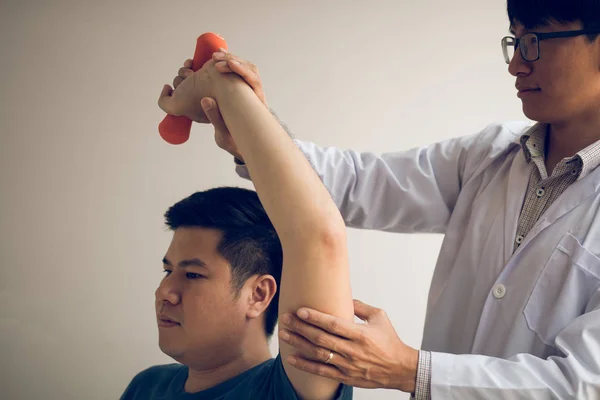 Aziatische fysiotherapeuten helpen bij de verhoging van de armen voor patiënten om Dum te verhogen — Stockfoto