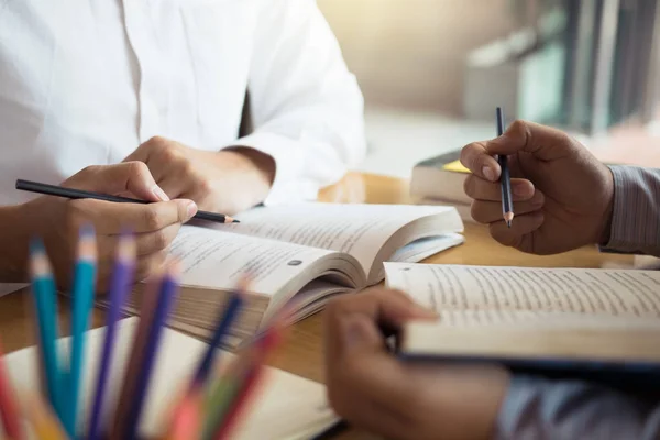 Los estudiantes están ayudando a hacer una lluvia de ideas sobre los deberes en la biblioteca — Foto de Stock