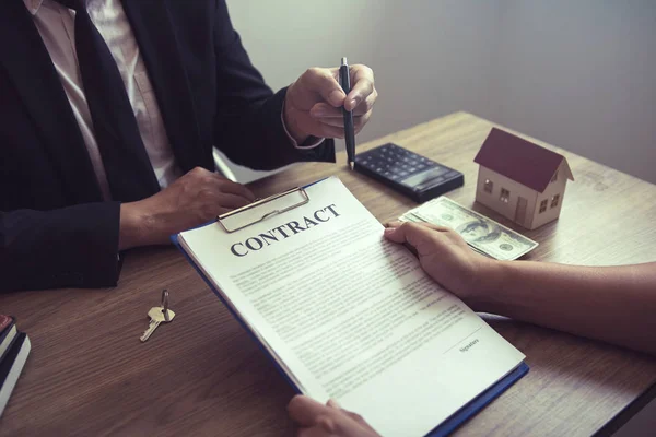 Agentes de vivienda hablando con compradores de vivienda que están firmando contratos en — Foto de Stock