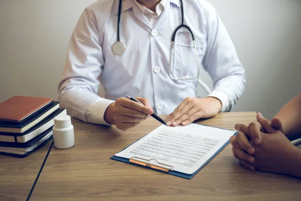 Arzt hält Stift in der Hand und spricht mit dem Patienten über Medikamente — Stockfoto