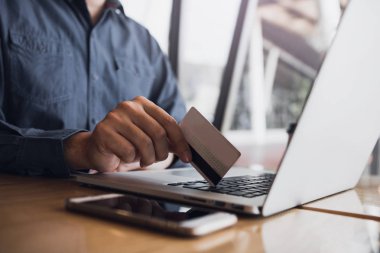 Kafede alışveriş online konsepti ile kredi kartı kullanan adam.