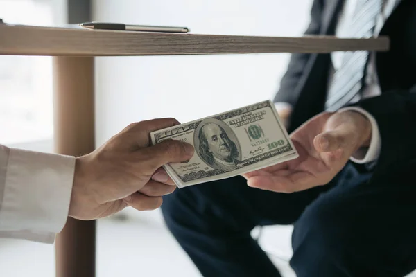 Οι επιχειρηματίες λαμβάνουν χρήματα κάτω από το γραφείο που είναι δωροδοκία — Φωτογραφία Αρχείου