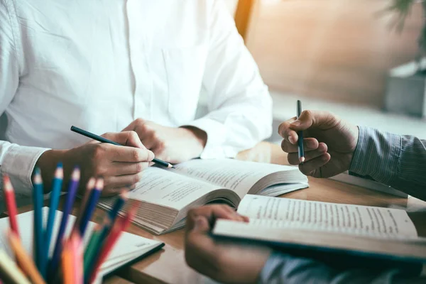 Asiático jóvenes estudiantes universitarios estudiando juntos sentado en des — Foto de Stock