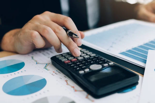 Primer plano de los inversores de mano están utilizando calculadoras para calcular th —  Fotos de Stock