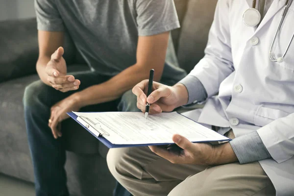 Arzt erfasst die Informationen des Patienten, während der Patient — Stockfoto