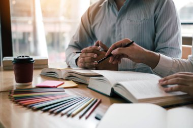 Kütüphanede sınava hazırlanan kitaplarla Asyalı öğrenci eğitimi.