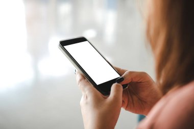 Kadın boş bir ekranda telefon kullanıyor.