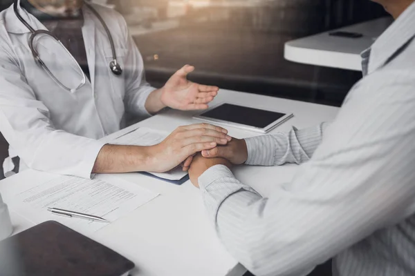 El médico toma de la mano y deja consejeros reconfortantes para el paciente. — Foto de Stock