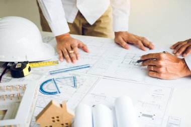 Mimarlar planları ile çalışan ve proje togeth tartışıyor