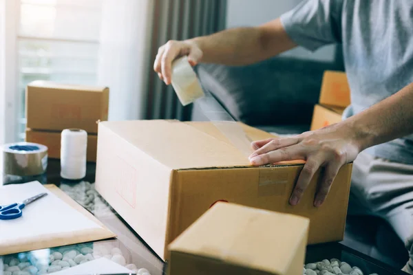 Asiatische Unternehmer Teenager verwenden das Klebeband, um die Schachtel zu versiegeln — Stockfoto