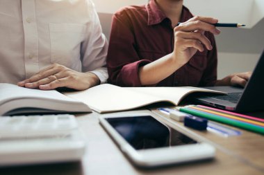 Öğrencilerin kütüphanede ödev hakkında beyin fırtınası için yardımcı oluyor