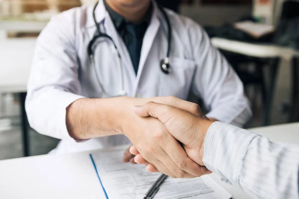 Médico estrechando la mano con paciente mayor en la sala de la clínica. — Foto de Stock