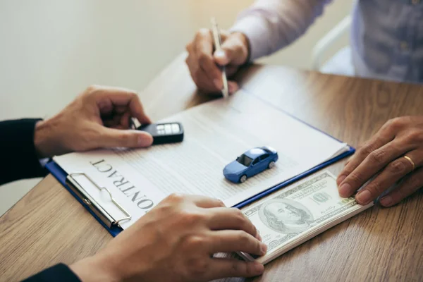 Los compradores de coches nuevos están firmando un contrato con un vendedor de coches en el — Foto de Stock