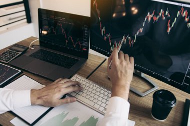 El yatırımcıların Yakın yatırım bilgileri hisse senedi piyasaları ve ortaklar notlar alarak ve performans verilerini analiz dizüstü bilgisayar işaret ediyor.