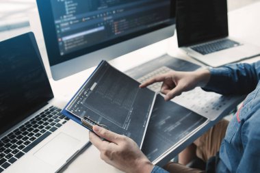 Asyalı adam kod programı geliştiricisi bilgisayar geliştirme web tasarım yazılımı ofiste masa üzerinde çalışıyor.