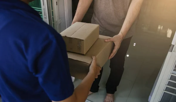 Close up of hands cargo staff are delivering cardboard boxes with parcels inside to the recipient\'s hand.