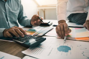 İki işadamı şirket bütçesi ve mali planlama ile ilgili hesaplamaları ofis odasında paylaşıyorlar..