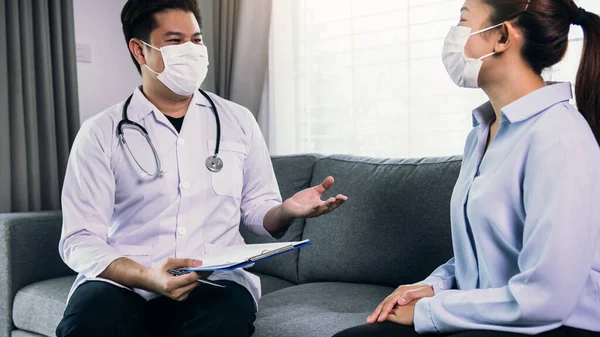 医者は家でマスクをしながら患者を訪ね ウイルス流行時の患者の治療を確認した — ストック写真