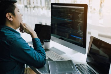 Asyalı adam kod programı geliştiricisi bilgisayar geliştirme web tasarım yazılımı ofiste masa üzerinde çalışıyor.