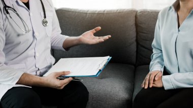 Doktor, virüs salgını sırasında hasta tedavisini kontrol etmek için evde maske takarken hastayı ziyaret etti..