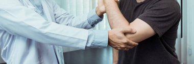 Asyalı fizyoterapistler ortopedik rehabilitasyon geçirmiş hastaların dirseklerini kontrol ediyorlar..