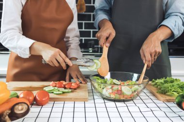 Asyalı çift mutfakta sağlıklı salata hazırlıyor..
