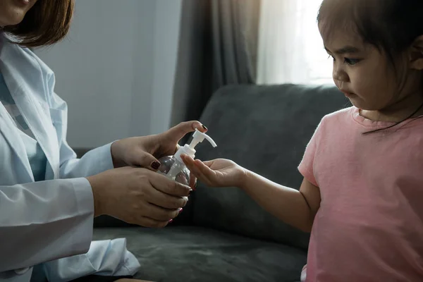 Female pediatrician is holding a bottle of alcohol hand sanitizer gel to wash hands kill germs and bacteria for children during the coronavirus outbreak.
