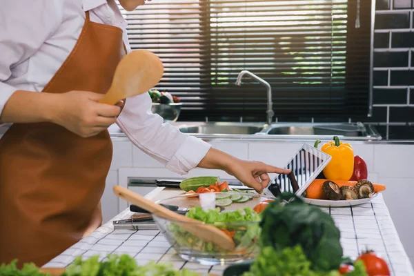 Asyalı kadınlar yemek pişirme sitelerinden yemek tarifleri bulmak için tablet kullanıyorlar..