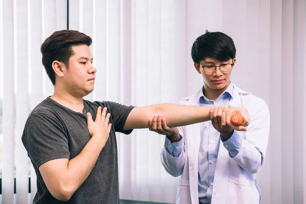 Asiático Joven Fisioterapeuta Masculino Ayudando Paciente Con Levantamiento Pesas Ejercicios —  Fotos de Stock