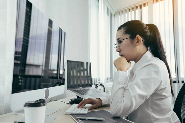 アジアの女性ソフトウェア開発者は オフィスでコードベースのシステムを分析することを心配しています — ストック写真