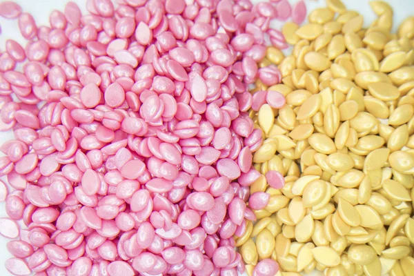 beyaz bir arka plan üzerine pembe ve altın mumya Depilasyon için granül vardır.
