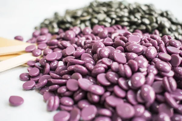 beyaz bir arka plan üzerinde boşaltma granüller vardır ve gümüş cila ve ahşap Depilasyon için sopa.