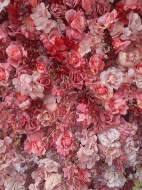 Yapay güllerin çok renkli arka planının seçici odak noktası, bitki örtüsünün karışık renkli dokusu.