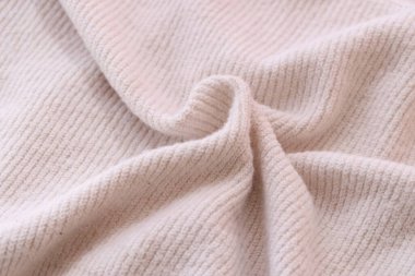 Örülmüş pastel pembe süveter dokusu, yakın çekim bej pembe örgü kumaş dokusu.