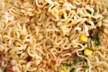 Baharatlı soslu erişte ve doğranmış yeşil soğan parçaları yakın.