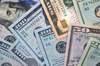 Büyük miktarlarda farklı banknotlar kapanıyor. Yüz elli yirmi on ve beş dolarlık banknotlar istiflendi.