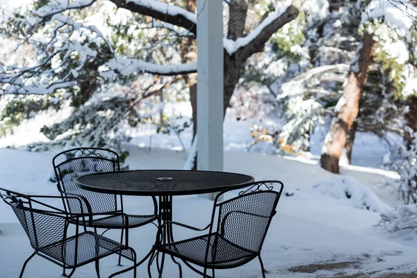 Table and chairs on a snow covered patio in winter