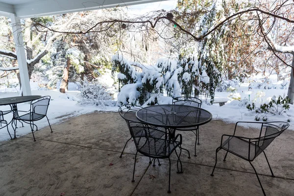 Table and chairs on a snow covered patio in winter
